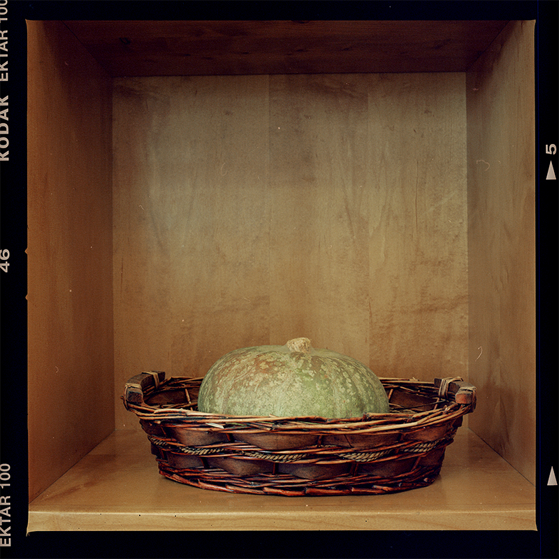Green pumpkin in wicker basket