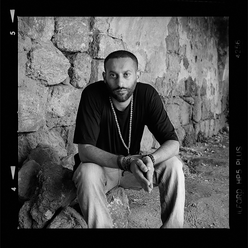 Rapper Tamer Nafar sitting in old stone building