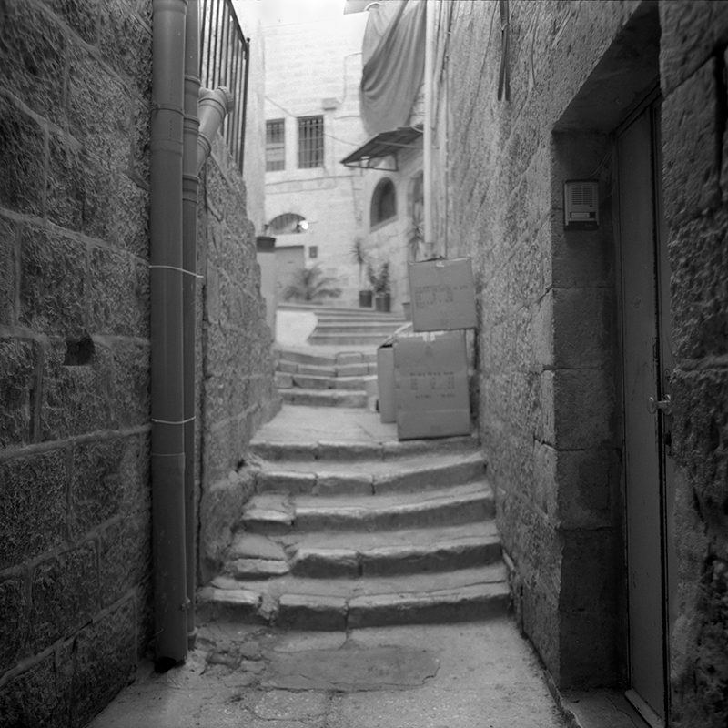 Black and white square photo of an alleyway in the old city of Jerusalem