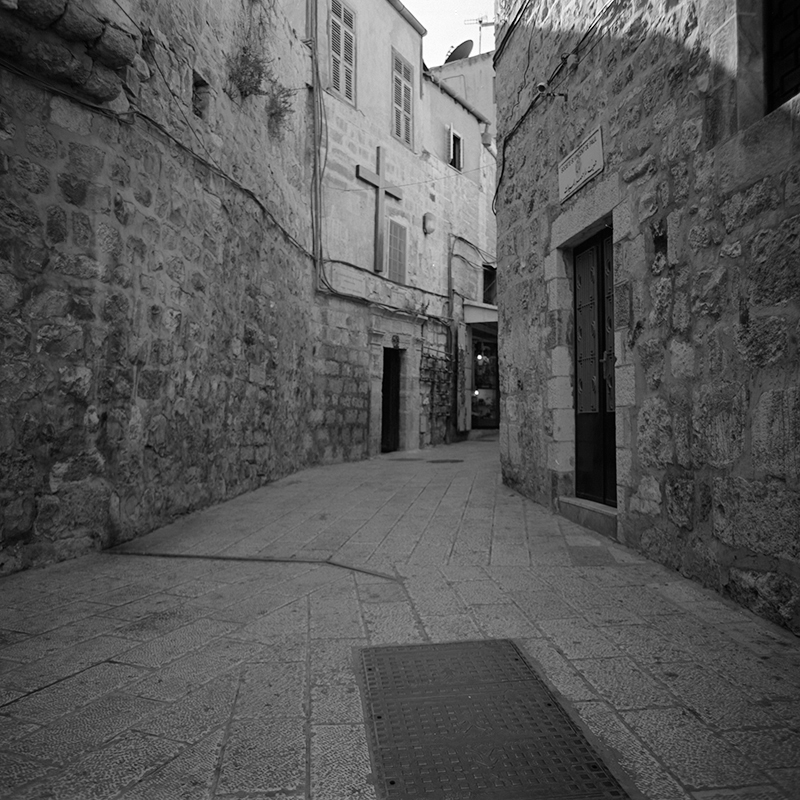 Black and white square photo of an alleyway in the old city of Jerusalem