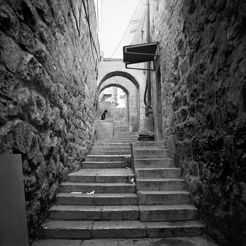 Black and white square photo of an alleyway in the old city of Jerusalem