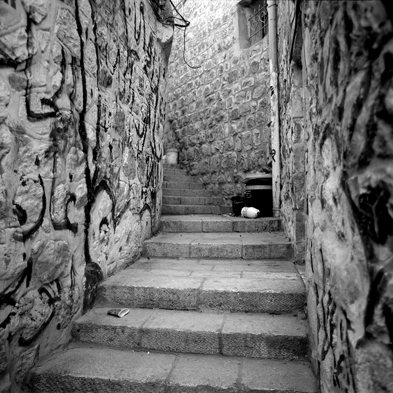 Black and white square photo of an alleyway in the old city of Jerusalem