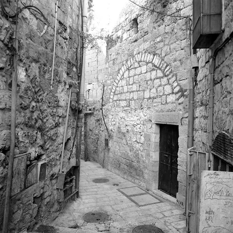 Black and white square photo of an alleyway in the old city of Jerusalem