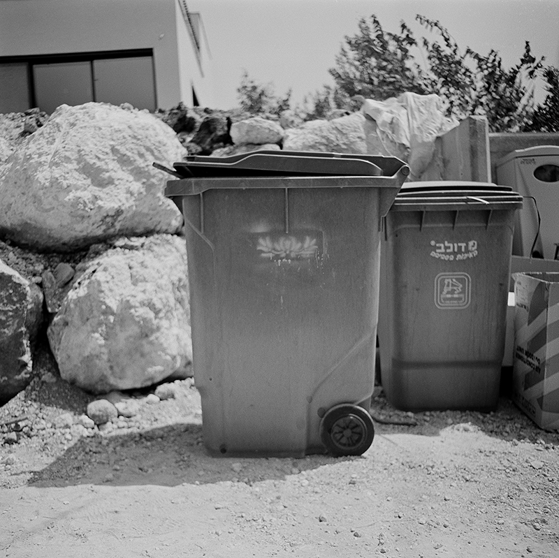 Black and white square photo of trashcan