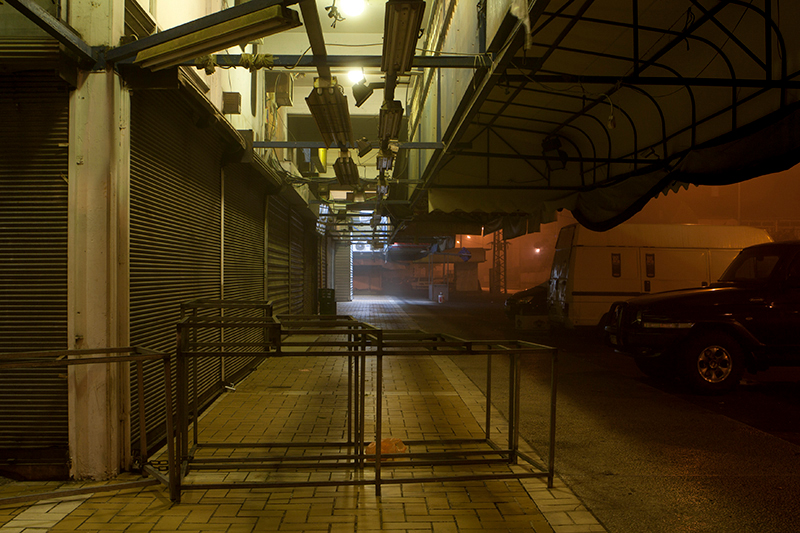 color nighttime photograph of empty sidewalk and closed shops