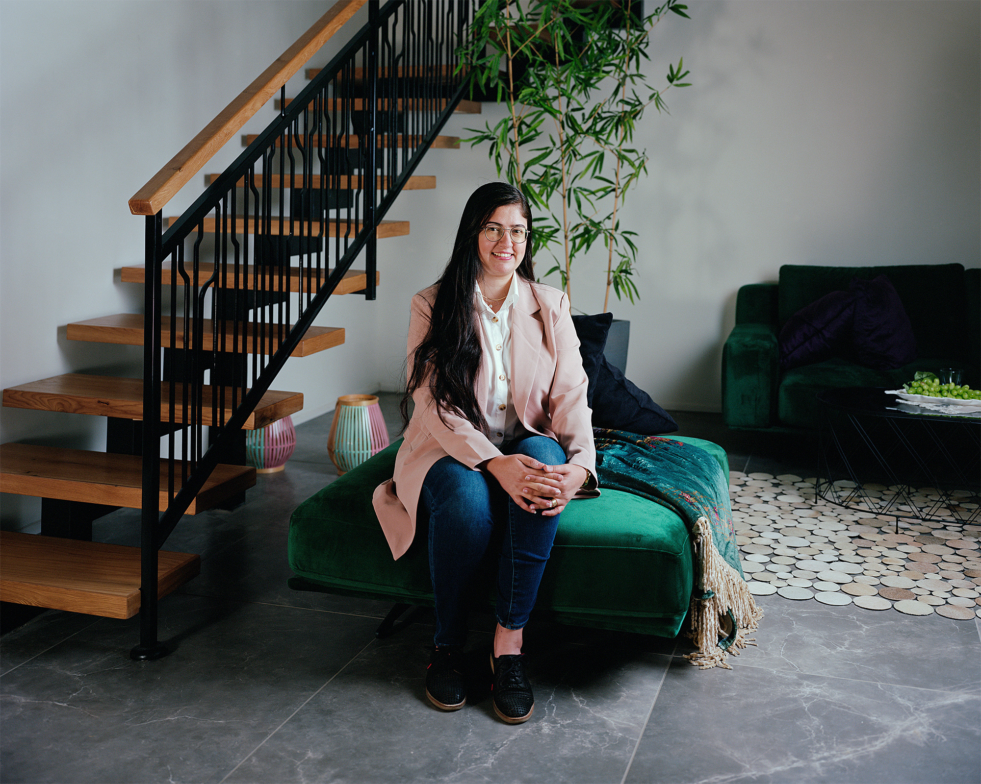 Young woman sitting on green sofa in her home