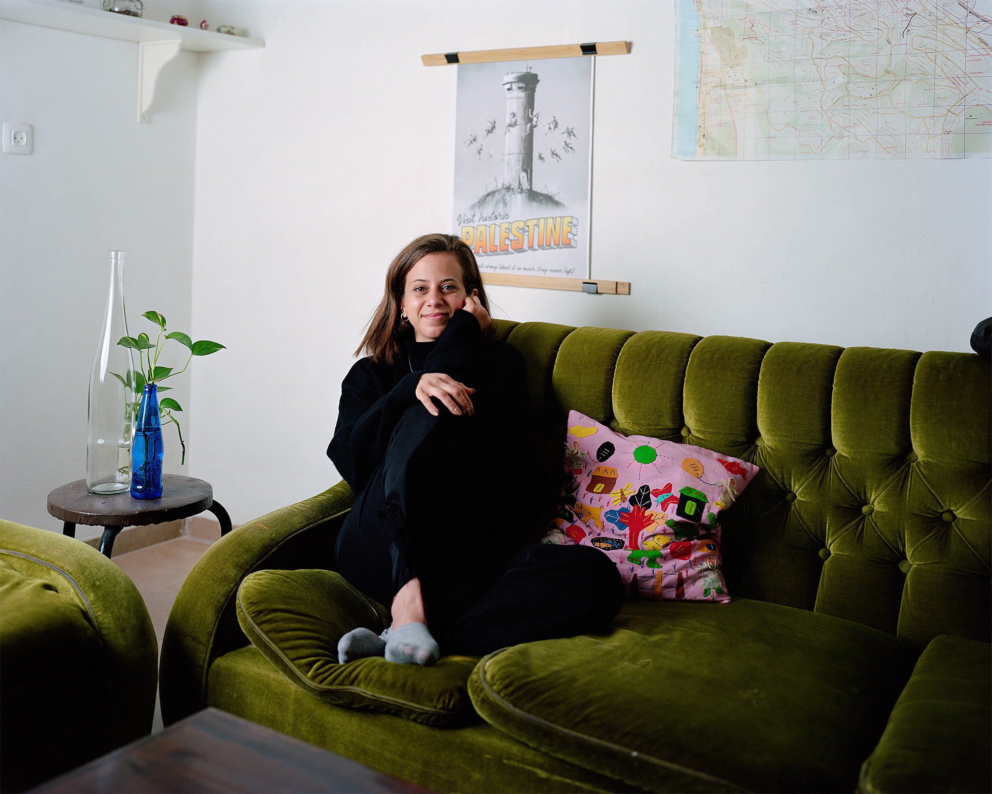 Young woman sitting on olive green couch