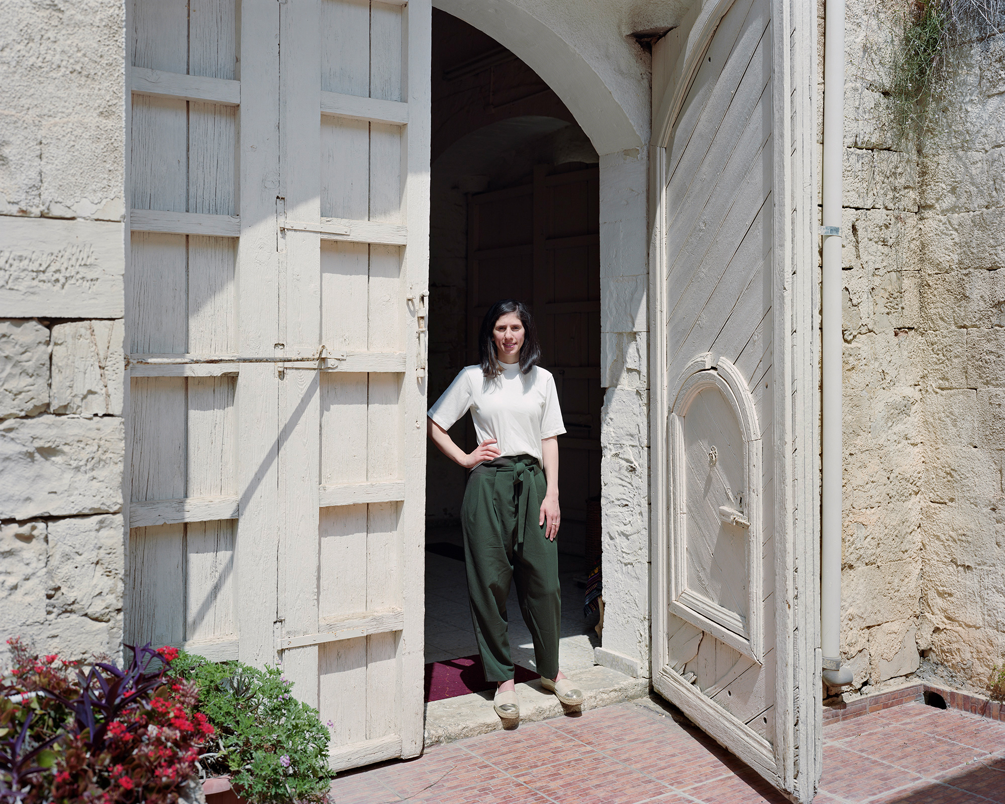 Young woman standing in big, old doorway